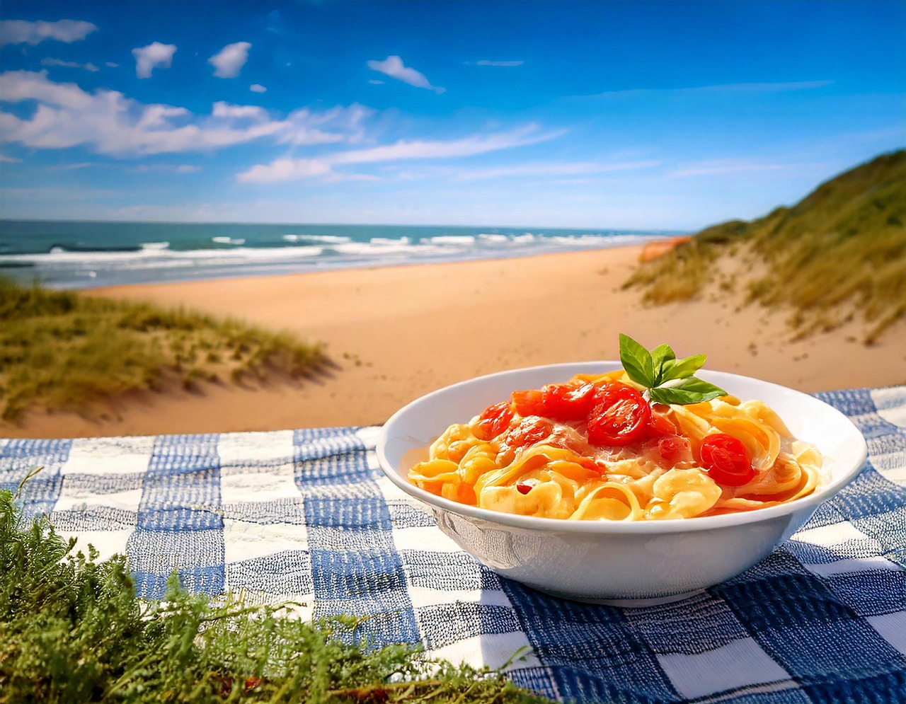 Pasta fredda con verdure colorate e basilico, servita in un piatto estivo.
